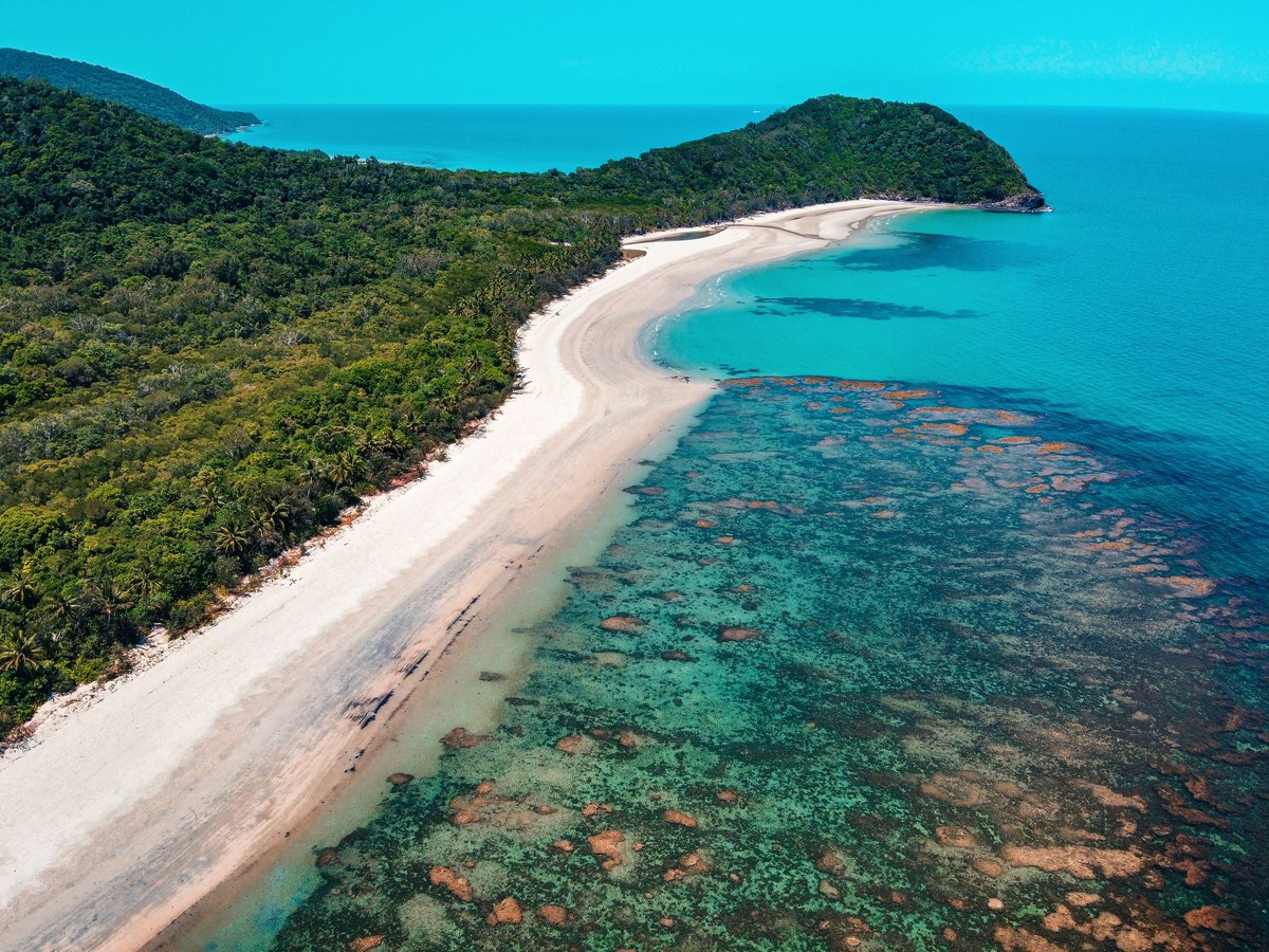 Aerial view of a rainforest coastline and reef near Cairns