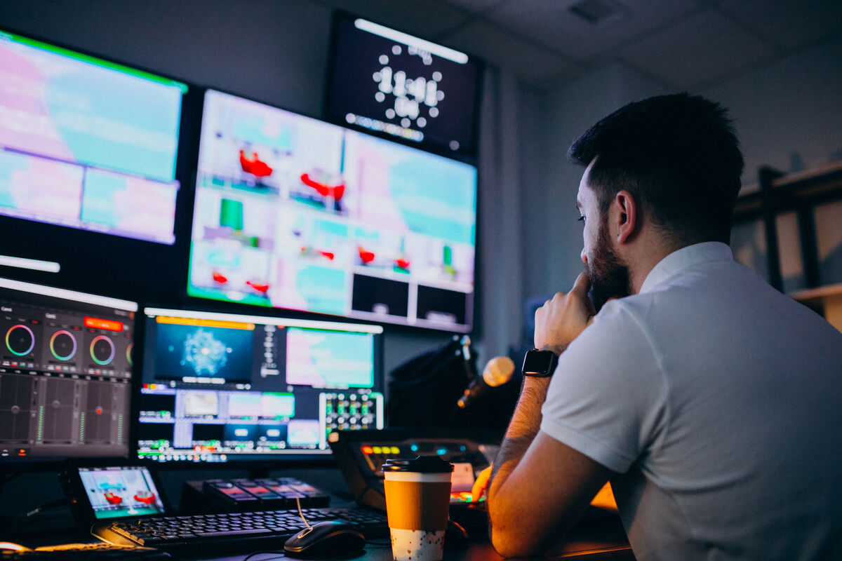Operator seated at a desk in front of multiple screens